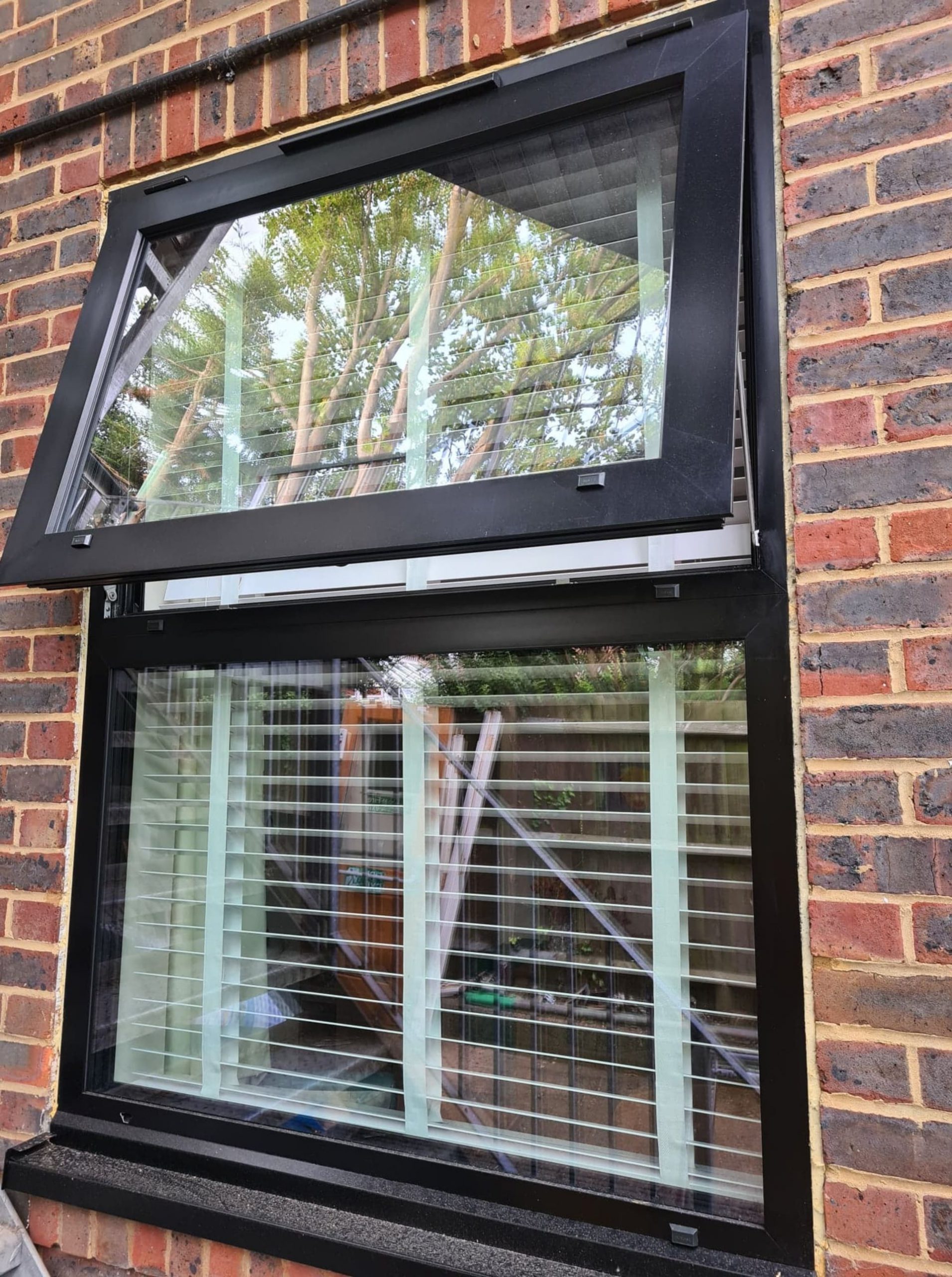 open black aluminium sash window London with white roller blinds