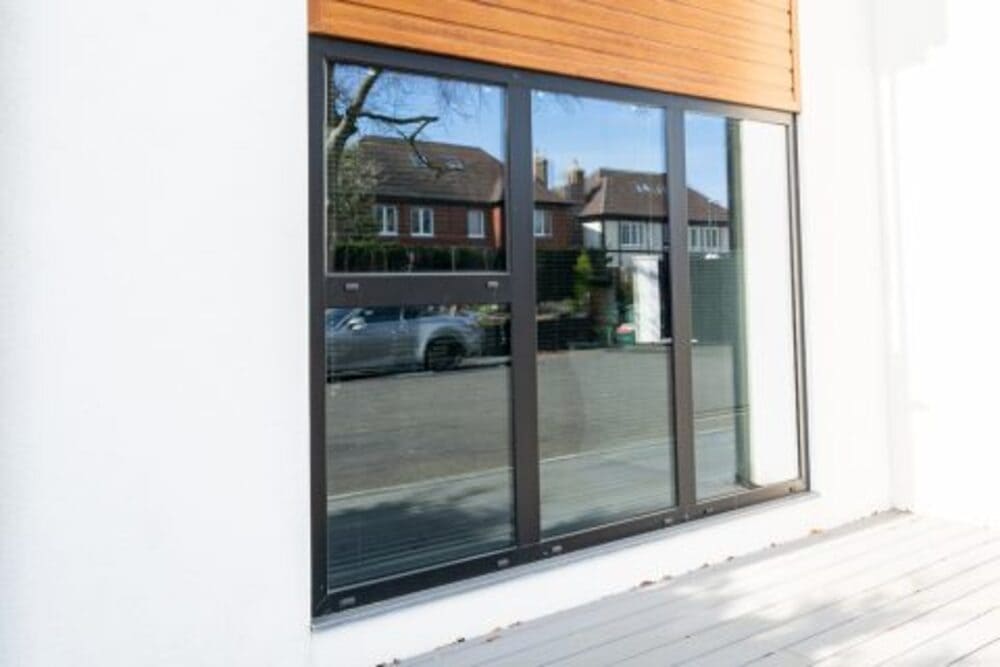 close-up of the new aluminium windows with external wooden roller shutters
