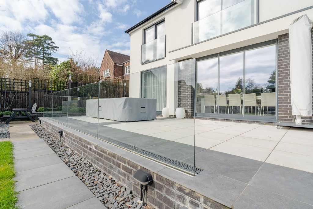 large patio with a glass fence and sliding patio doors London