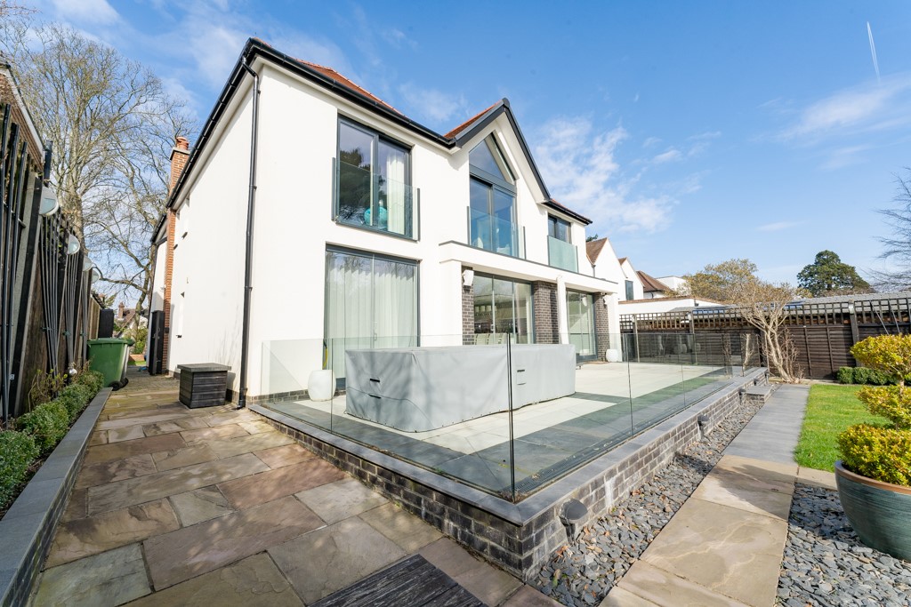 white facade modern house with large patio with glass fence and large patio doors London
