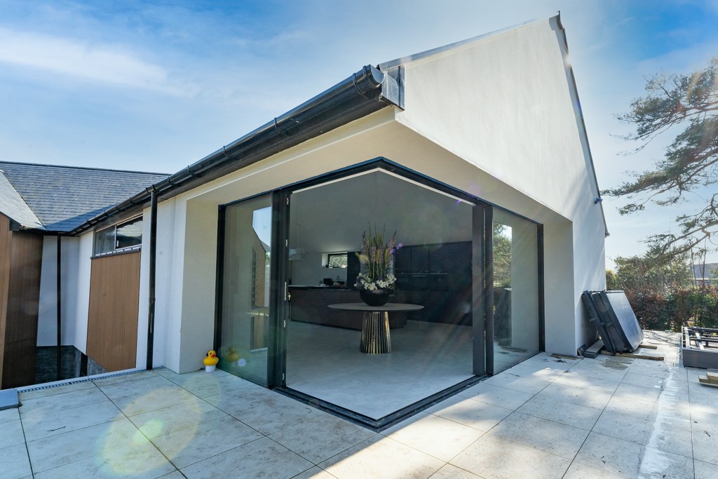 installation of large aluminium sliding doors London in the corner of the modern house