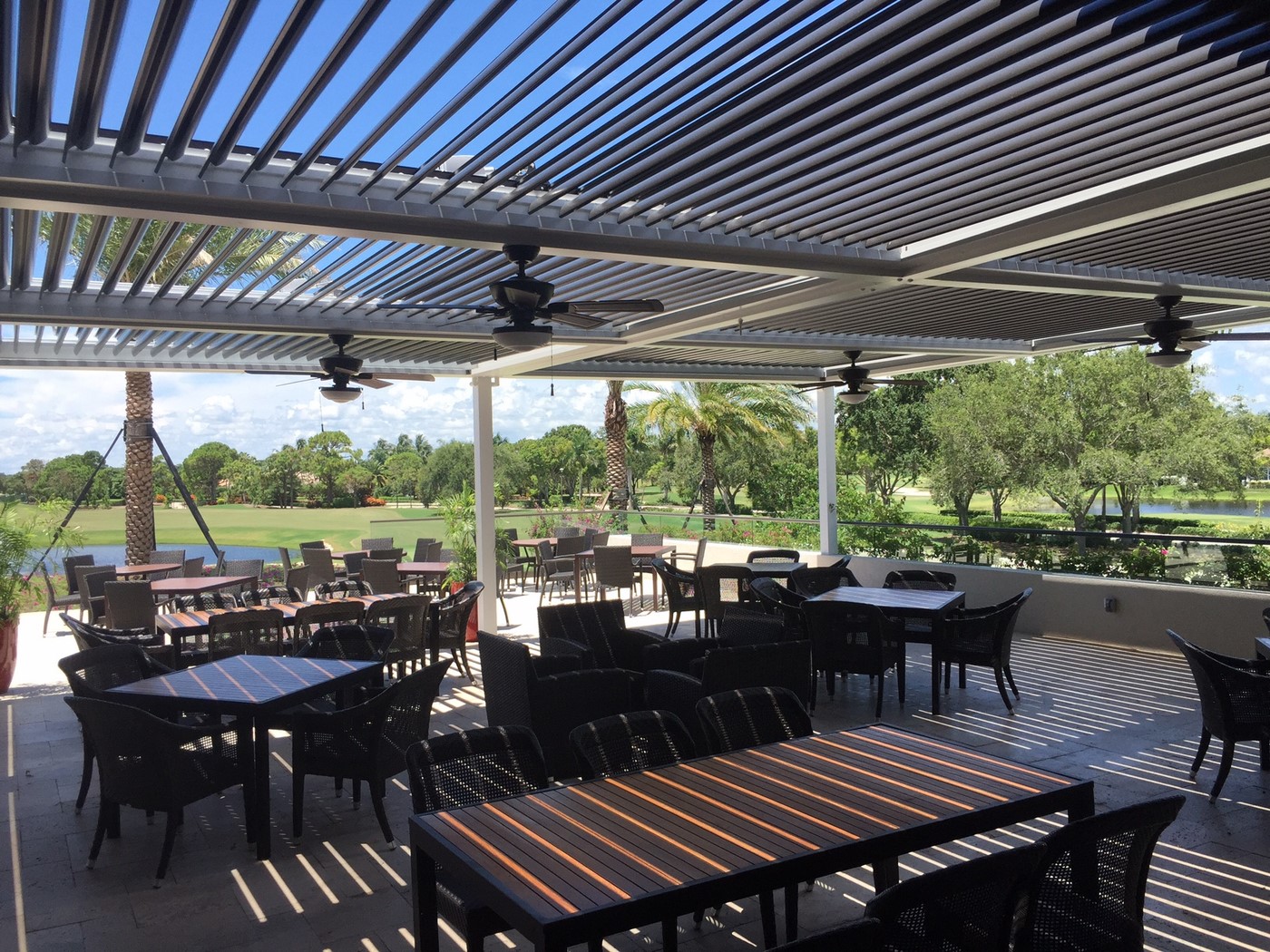 large covered restaurant patio with multiple tables and chairs
